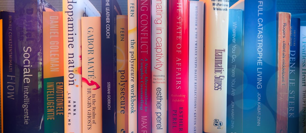 Stack of books relating to addiction recovery and mental health